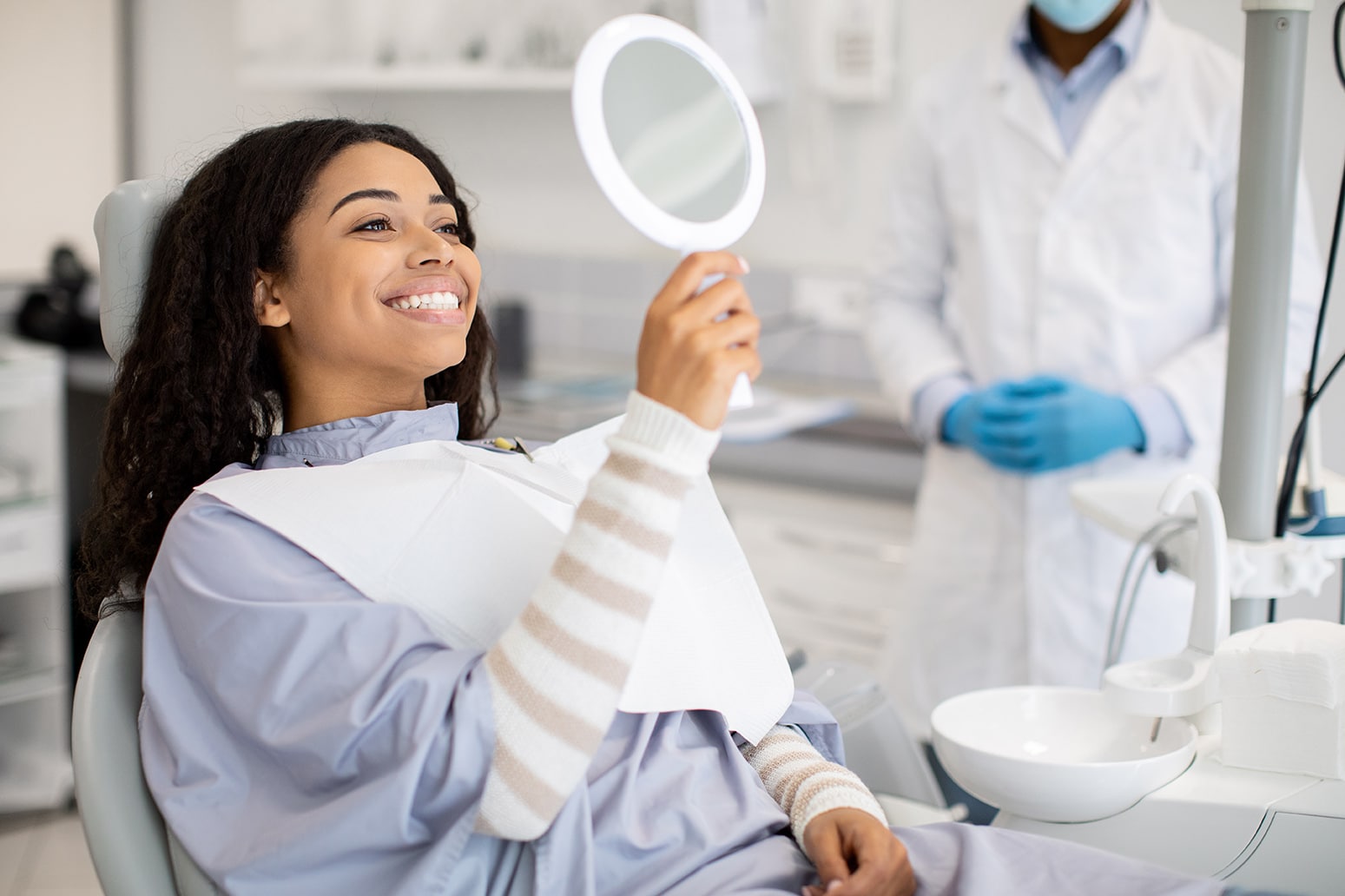 dental patient looking into a mirror during cavity filling appointment at stefan family dental